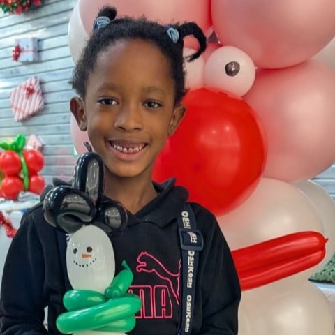 Girl in Hamilton with twisting balloon model by balloon column in Hamilton Ontario